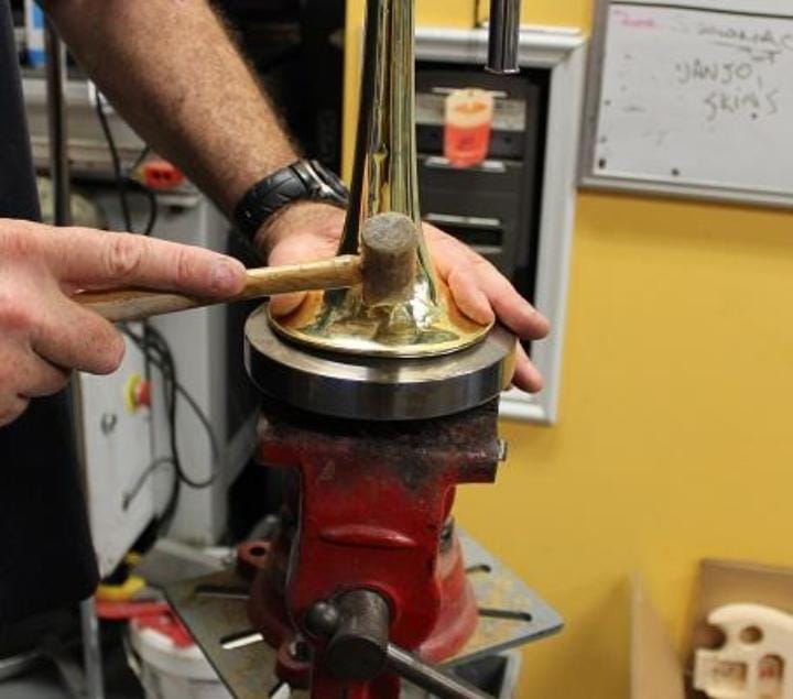 Trabalho de manutenção em instrumento de metal na bancada